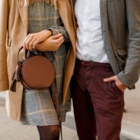 Close up fashion details of elegant woman and man . Trendy accessories, casual dress and suit. Couple in love walking in European city.
